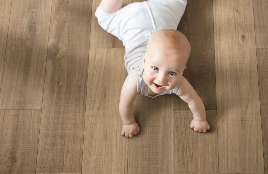 Baby crawling on light oak wood-look vinyl plank flooring.