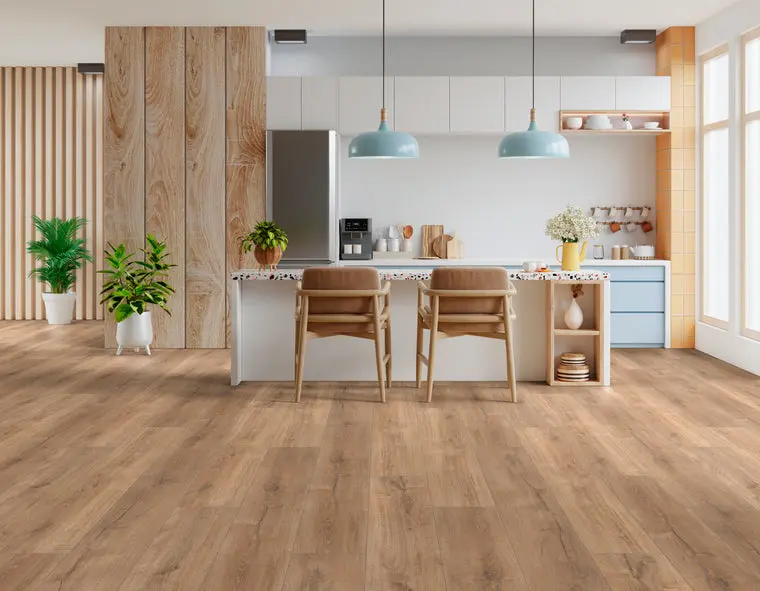 Modern kitchen island with light oak wood vinyl plank flooring and blue pendant lights.